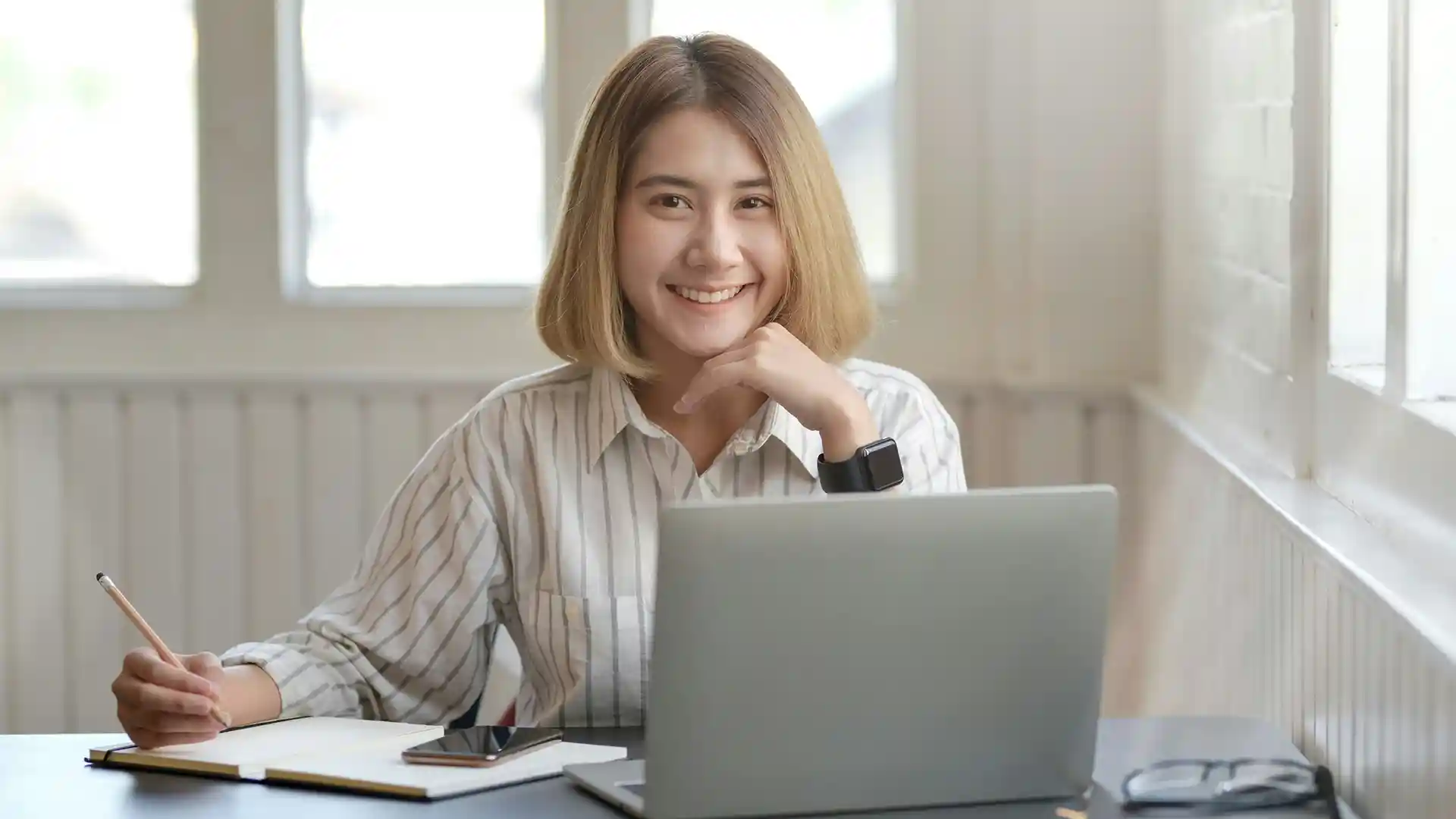 Asian woman sitting at a desk.