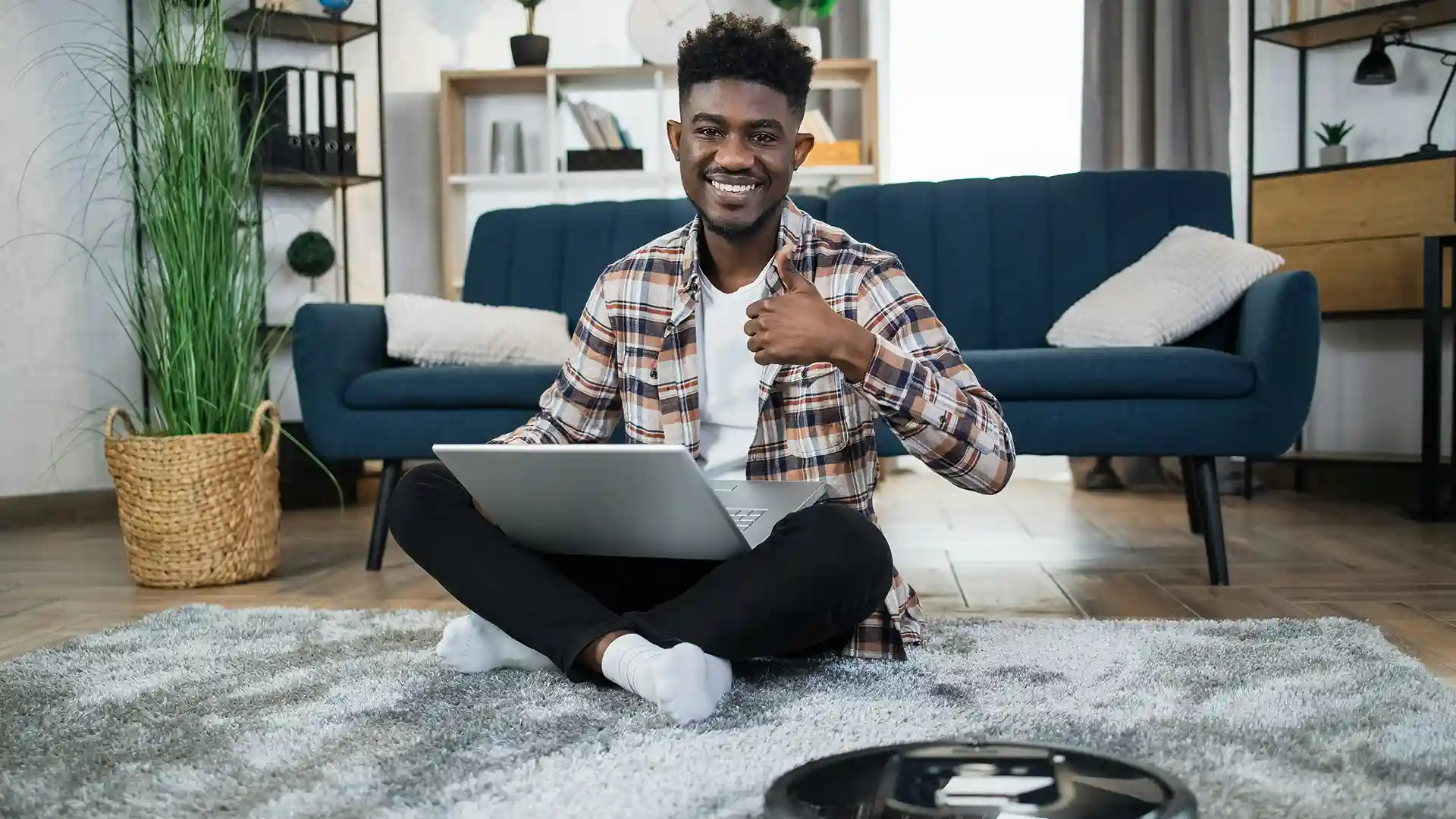 Black man sitting on the floor of a living room.