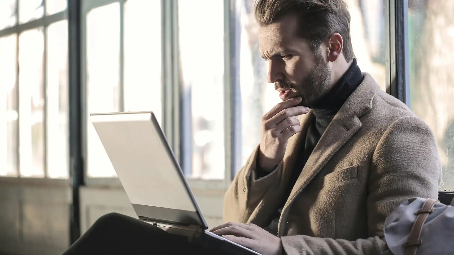 Thoughtful man using a laptop.