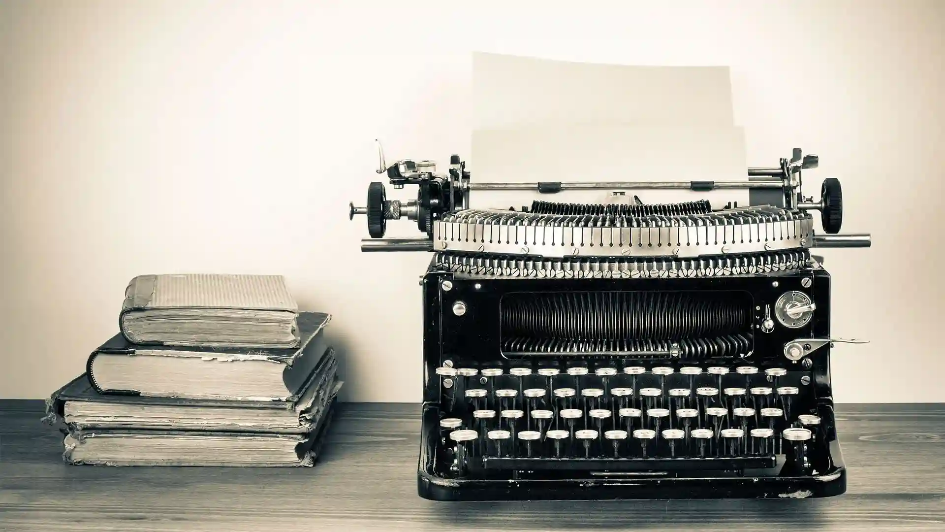 Vintage typewriter and stack of books.