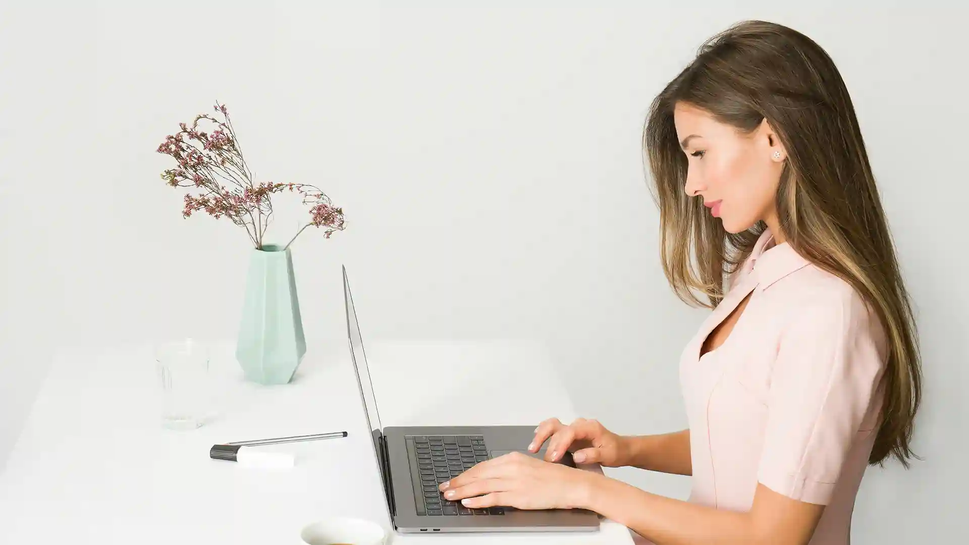 Frau in hellem Kleid und ein Laptop.